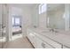Bathroom featuring double sinks, white cabinets, and a glass shower at 657 Harness St, Erie, CO 80516