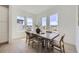 Dining room featuring a wooden table with seating for six and view from three large windows at 657 Harness St, Erie, CO 80516