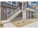 Up-close exterior view showing an entrance of a modern townhome, showcasing a white staircase, and brown brick at 657 Harness St, Erie, CO 80516