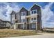 Charming townhome exterior featuring modern design, brick accents, and a inviting covered balcony on a sunny day at 657 Harness St, Erie, CO 80516