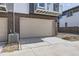 Attached garage with beige door and brick exterior at 657 Harness St, Erie, CO 80516