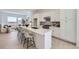 Modern kitchen with white cabinets, quartz countertops, an island with seating, open to the living area at 657 Harness St, Erie, CO 80516
