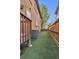 Side yard featuring synthetic grass, wood fence, and access to the rest of the home at 8053 E Maple Ave, Denver, CO 80230
