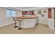 Basement bar area with wood countertop, seating, and decorative shelving, creating a cozy entertainment space at 8053 E Maple Ave, Denver, CO 80230