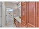 Bathroom featuring wood cabinets, dual sinks, and a separate toilet room at 8053 E Maple Ave, Denver, CO 80230