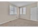Bright bedroom featuring neutral walls, carpet, and a large window with stylish white shutters at 8053 E Maple Ave, Denver, CO 80230