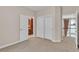 Bedroom with neutral carpet and doorways to the bathroom and hall, offering a convenient and accessible layout at 8053 E Maple Ave, Denver, CO 80230