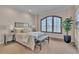 Bright bedroom with a large window, neutral decor, and a comfortable seating area at 8053 E Maple Ave, Denver, CO 80230