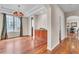 Dining area showcasing hardwood floors, cabinet, and chandelier, with a view to the kitchen at 8053 E Maple Ave, Denver, CO 80230