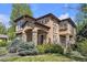 Beautiful two-story home with stone accents, stucco siding, arched entry and landscaped front yard at 8053 E Maple Ave, Denver, CO 80230