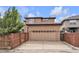 Two-story home showcasing a two car garage and fenced in backyard at 8053 E Maple Ave, Denver, CO 80230