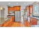 Spacious kitchen with wood flooring, stainless steel appliances, and granite countertops at 8053 E Maple Ave, Denver, CO 80230