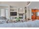 Comfortable living room featuring built-in shelving, fireplace, and a partial view of the kitchen at 8053 E Maple Ave, Denver, CO 80230