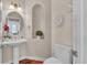 Powder room featuring pedestal sink, decorative wall art, and hardwood floors at 8053 E Maple Ave, Denver, CO 80230
