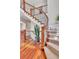 Elegant staircase with wood railing, iron spindles and carpeted steps leading to the upper level at 8053 E Maple Ave, Denver, CO 80230