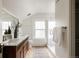 Bright bathroom with a double vanity, glass-enclosed shower, and natural light from the window at 4261 Julian St, Denver, CO 80211