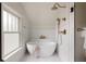 Elegant bathroom featuring a freestanding tub, brass fixtures, white tiling, and a glass enclosed shower at 4261 Julian St, Denver, CO 80211