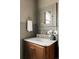 Stylish bathroom showcasing a wood vanity with marble countertop and brass fixtures at 4261 Julian St, Denver, CO 80211