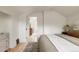 Bedroom leading to a bathroom, featuring hardwood floors, a neutral rug, and white walls at 4261 Julian St, Denver, CO 80211