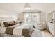 Comfortable bedroom featuring a plaid headboard, cozy bedding, and ample natural light from the window at 4261 Julian St, Denver, CO 80211