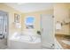 Bright bathroom with a soaking tub, glass shower, and granite vanity featuring a large sunny window at 9921 Spring Hill Pl, Highlands Ranch, CO 80129