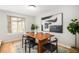 Elegant dining room featuring a modern painting, natural light, and a wood table at 9921 Spring Hill Pl, Highlands Ranch, CO 80129
