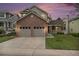 Charming two-story home featuring a brick facade and a well-maintained lawn at dusk at 9921 Spring Hill Pl, Highlands Ranch, CO 80129