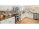 Bright kitchen featuring stainless appliances, granite counters, tile backsplash, modern cabinetry, and hardwood floors at 9921 Spring Hill Pl, Highlands Ranch, CO 80129