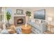 Inviting living room featuring a brick fireplace, comfortable seating, and stylish decor at 9921 Spring Hill Pl, Highlands Ranch, CO 80129