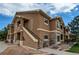 View of a condominium showing the private entrance, stone accents and mature landscaping at 4730 Copeland Cir # 204, Highlands Ranch, CO 80126