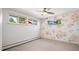 Comfortable bedroom with three large windows and a decorative floral accent wall at 25392 Westridge Rd, Golden, CO 80403