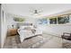 Bright main bedroom with ceiling fan, neutral decor, a large rug, and ample natural light from three large windows at 25392 Westridge Rd, Golden, CO 80403