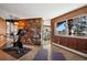 Exercise room features a stone accent wall, adjacent spiral staircase, and a picture window at 25392 Westridge Rd, Golden, CO 80403