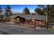 Charming exterior with stone accents, fenced yard, and paved driveway at 25392 Westridge Rd, Golden, CO 80403