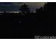 Distant night view of the home and yard with a long paved driveway at 25392 Westridge Rd, Golden, CO 80403