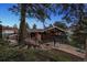 Exterior view of a home with a deck, a detached garage, and steps leading to the property at 25392 Westridge Rd, Golden, CO 80403