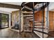 Living room featuring spiral staircase, stone fireplace, hardwood floors, and adjacent wine rack at 25392 Westridge Rd, Golden, CO 80403