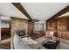 Open living room boasts a stone fireplace, spiral staircase, wooden beams and built-in shelving at 25392 Westridge Rd, Golden, CO 80403