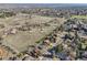 Wide aerial view shows neighborhood homes along a tree lined street and open land in the background at 4152 S Vrain St, Denver, CO 80236