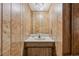 Small bathroom featuring wood paneling, with sink and cabinet for storage at 4152 S Vrain St, Denver, CO 80236