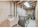 Unfinished basement laundry room features utility sink and washer and dryer hookups at 4152 S Vrain St, Denver, CO 80236