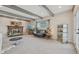Comfortable living room featuring a brick fireplace, wooden beams, and soft carpeting at 4152 S Vrain St, Denver, CO 80236