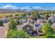 An aerial view of a neighborhood, with homes nestled amongst mature trees and beautiful mountain views in the distance at 6590 S Tabor St, Littleton, CO 80127