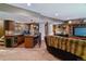 Finished basement area with a bar, desk, television, and comfortable seating at 6590 S Tabor St, Littleton, CO 80127