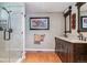Bathroom showcasing a glass-enclosed shower, a double sink vanity, and warm wood accents at 6590 S Tabor St, Littleton, CO 80127