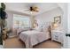 Bright bedroom with decorative lamps, white bedding, and a ceiling fan at 6590 S Tabor St, Littleton, CO 80127