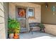 Inviting front porch with seasonal wreath, bench, colorful potted plants, and decorative details for a warm welcome at 6590 S Tabor St, Littleton, CO 80127