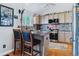 Modern kitchen with stainless appliances, breakfast bar, and decorative backsplash offering both style and functionality at 6590 S Tabor St, Littleton, CO 80127