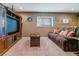 Relaxing living room featuring a large TV, a sectional sofa, and soft lighting at 6590 S Tabor St, Littleton, CO 80127