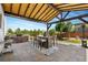 Inviting covered back patio with an outdoor kitchen, a built-in grill, a dining table, and manicured landscaping at 14110 Pastel Ln, Parker, CO 80134